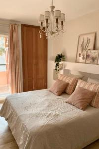 een slaapkamer met een groot bed met een kroonluchter bij MARBELLA - ALICATE BEACHFRONT Apartment - 6 in Marbella +43 foto's