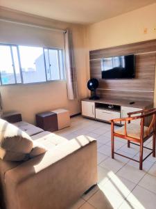 sala de estar con sofá y TV de pantalla plana en Residencial Kremer, en Florianópolis