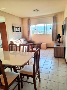 1 dormitorio y sala de estar con mesa y sillas. en Residencial Kremer, en Florianópolis