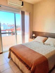 1 dormitorio con cama grande y ventana grande en Residencial Kremer, en Florianópolis