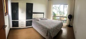a bedroom with a bed and a dresser and a window at Casa Barra da lagoa/ Mole in Florianópolis