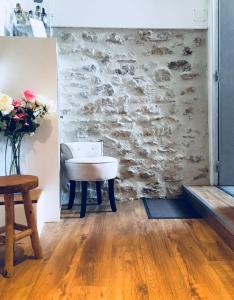 a room with a table and a stone wall at Duo Détente in Le Chenoy