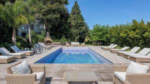 una piscina con tumbonas y una mesa en Luxurious royal estate in historic Sintra paradise, en Sintra