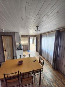 a dining room with a wooden table and chairs at Cabañas Roma in Valdivia