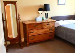 a bedroom with a dresser and a bed with a mirror at Tuscany 2900 - Classic Italian Style 3BR w Parking near Airport in Philadelphia