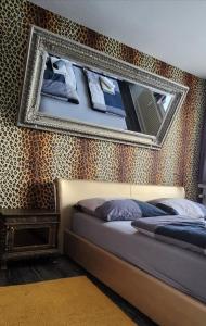 een slaapkamer met een bed en een spiegel aan de muur bij Apartment Düsseldorf-Süd in Düsseldorf