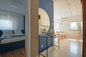 a bedroom with a bed and a table with a laptop at Niebieski Kwadrat - garaż podziemny + AC! in Rzeszów