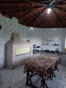 a kitchen with a table and a stove in it at Pousada Lambaris Pereque Guarujá in Guarujá