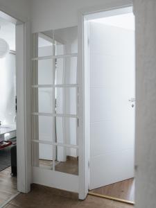 biała szafa ze szklanymi drzwiami w pokoju w obiekcie Apartman Stadion w mieście Osijek