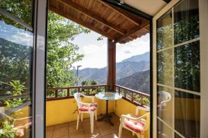 a balcony with a table and chairs and mountains at Lightbooking Claudia Hermigua La Gomera in Hermigua