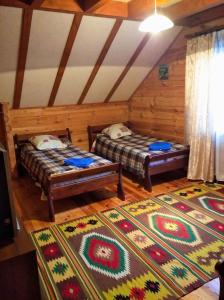 Cette chambre dispose de 2 lits et d'un tapis. dans l'établissement Лісова хатинка, à Haivka