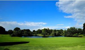 a golf course with a lake in the middle of a field at Golf Club Marco Simone in Marco Simone