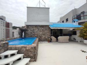 uma piscina no telhado de um edifício em Cobertura Enseada Guarujá - 250 metros da praia no Guarujá