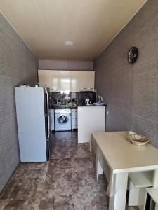 a kitchen with a white refrigerator and a table at Villa Platinum in Tskaltubo