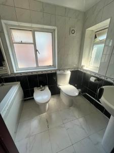 a bathroom with two toilets and a tub and a sink at 17 Howard Road. Southampton in Southampton