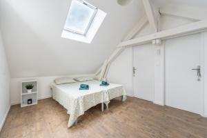 a white bedroom with a bed and a window at Duplex et Studio Saint Martin Le Beau in Saint-Martin-le-Beau