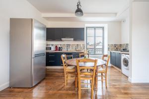 a kitchen with a table and chairs and a refrigerator at Duplex et Studio Saint Martin Le Beau in Saint-Martin-le-Beau
