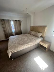 a bedroom with a large bed and a night stand at 17 Howard Road. Southampton in Southampton