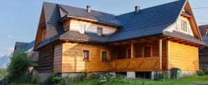 a wooden house with a black roof at Murań1 in Bukowina Tatrzańska