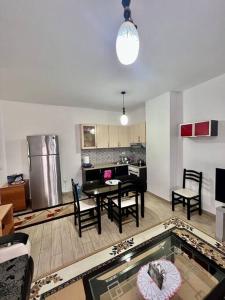 地拉那的住宿－Fresk Area，一间带桌椅的客厅和一间厨房