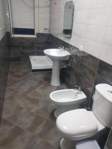 a bathroom with two toilets and a sink at Fresk Area in Tirana