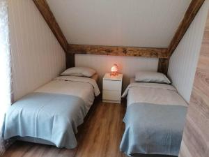a room with two twin beds in a attic at Viltė Rest House 