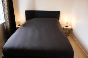 a bed in a room with two lamps on two tables at Arty - Premium - Parking box privé - Balcon - Sauna en option in Saint-Priest