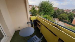 einen Balkon mit einem Schreibtisch, einem Tisch und einem Stuhl in der Unterkunft Arty - Premium - Parking box privé - Balcon - Sauna en option in Saint-Priest