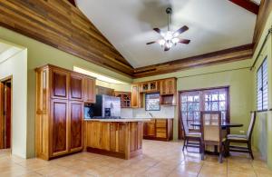 a kitchen with wooden cabinets and a ceiling fan at Villa Maya Gold Standard and Certified in San Ignacio