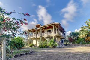 een huis met een veranda rondom bij Villa Maya Gold Standard and Certified in San Ignacio