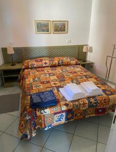 ein Bett in einem Hotelzimmer mit Büchern darüber in der Unterkunft Appartamento Calarossa Sardegna CasaRosa in Isola Rossa