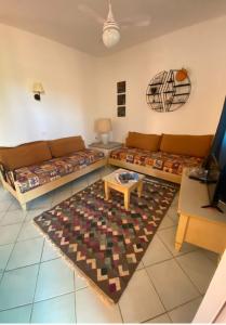 - un salon avec deux canapés et une table dans l'établissement Appartamento Calarossa Sardegna CasaRosa, à Isola Rossa