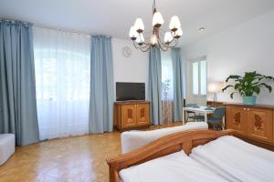 Sala de estar con 2 camas y TV en Exclusive Entry: Cozy Guestroom, en Baden