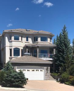 une grande maison blanche avec un garage blanc dans l'établissement Rocky Mountain View Bed & Breakfast, à Cochrane
