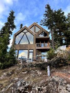 a house on top of a hill with trees at Basecamp Strathcona Park View Chalet in Mount Washington