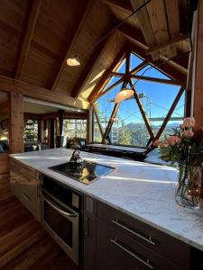 a kitchen with a counter with a sink and a window at Basecamp Strathcona Park View Chalet in Mount Washington