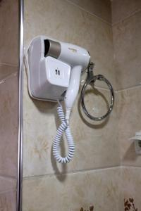 Hotel Plaza 777 في سمرقند: هاتف أبيض معلق على جدار في الحمام