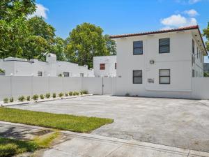 ein weißes Haus mit einem Zaun und einer Einfahrt in der Unterkunft Wynwood Apts Boutique Hotel in Miami