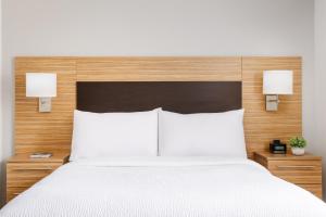 a bedroom with a large white bed with two lamps at TownePlace Suites Manchester-Boston Regional Airport in Manchester