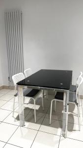 uma mesa preta e cadeiras num quarto com um radiador em Comfortable Modern Bedroom Space with Ensuite near Bramall Lane Stadium and RHH em Sheffield