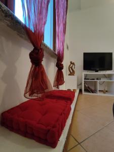 sala de estar con sofá rojo y TV en Home4You, en Cremona