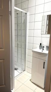 uma casa de banho branca com um chuveiro e um lavatório. em Comfortable Modern Bedroom Space with Ensuite near Bramall Lane Stadium and RHH em Sheffield
