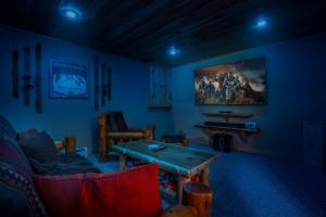 a living room with a table in a blue room at Ski Chalet 6 min to Sunday River - Hot Tub, Home Theater, Game Room, Fire Pit - Sleeps 12 in Bethel