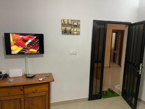 Habitación con TV de pantalla plana en la pared en Villa sokhna ndeye mbacke, en Dakar