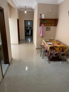 Villa sokhna ndeye mbacke في داكار: غرفة مع طاولة وكراسي وممر