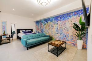 ein Wohnzimmer mit einem blauen Sofa und einem Bett in der Unterkunft Privada Stays - Lofts with Private Pool and Oasis, near Eagle Beach in Palm-Eagle Beach
