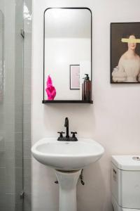 ein weißes Badezimmer mit einem Waschbecken und einem Spiegel in der Unterkunft Quiet 2 Bed Private Patio Steps from Parque Mexico in Escandon in Mexiko-Stadt