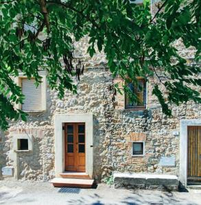 een stenen gebouw met een houten deur en ramen bij La grotta dei nonni in Sassa