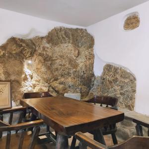 ein Esszimmer mit einer großen Felswand in der Unterkunft La grotta dei nonni in Sassa