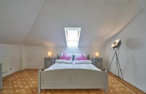 a bedroom with a white bed with pink pillows at Big Apartment in Guesthouse in Baden